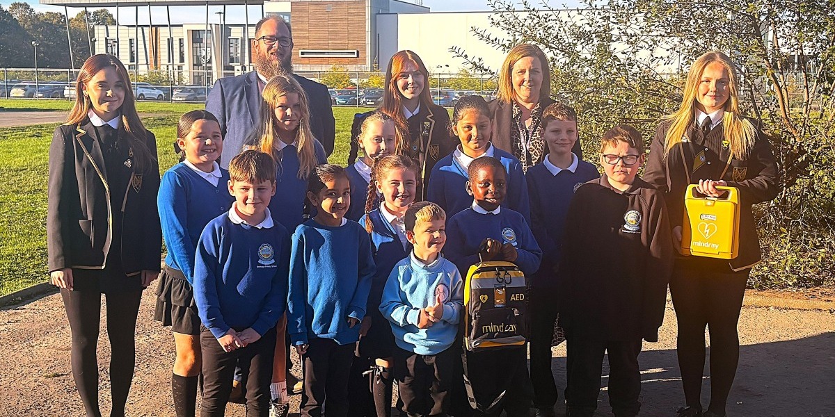 📷 The new defibrillators with pupils from Grangemouth High School and Bowhouse Primary School along with their Acting Headteacher, Jillian Millar.